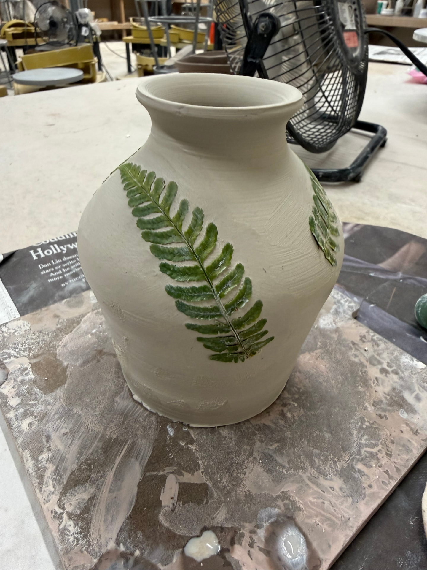 Unfired vase with fern leaves pressed into the wet clay