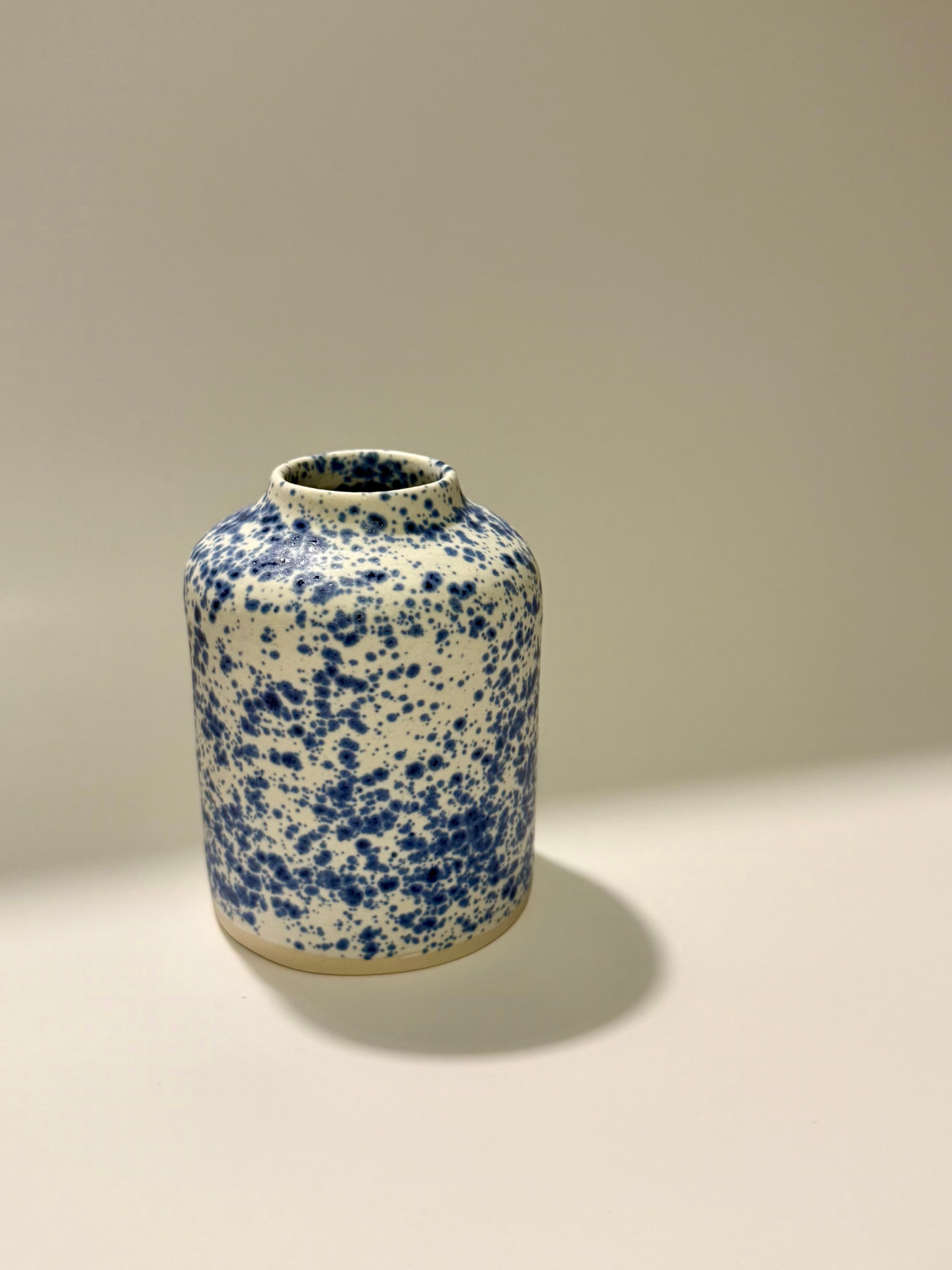 Speckled stoneware bud vase with a narrow neck