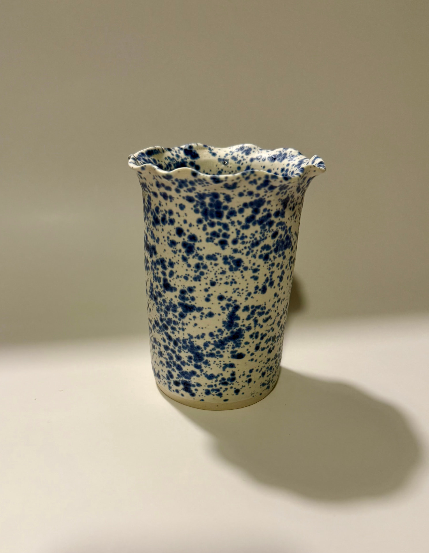 Speckled vase with a ruffled, wavy rim